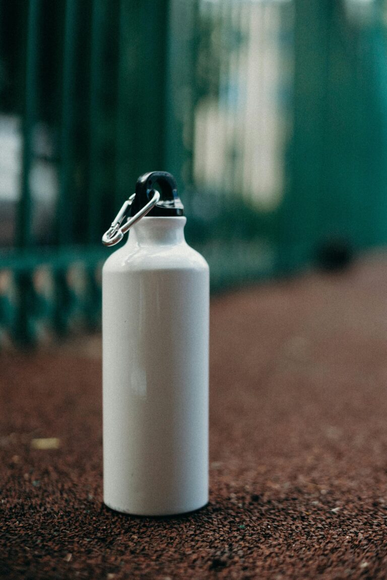 White eco-friendly water bottle on a sports track promotes zero waste and sustainability.